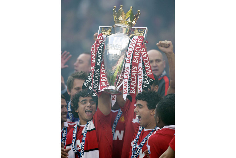 Manchester United's Rafael Da Silva, left, and Fabio Da Silva, right, are seen celebrating with the English Premier League trophy after their match against Blackpool at Old Trafford, Manchester, England, Sunday, May 22, 2011. Manchester United celebrated w