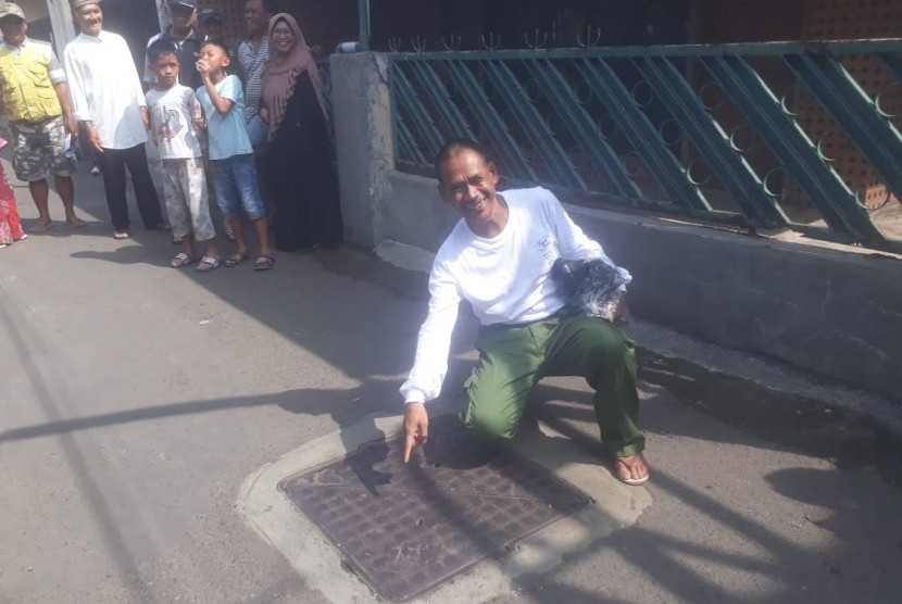 Mang Uha, pria asal Cicadas Bandung yang viral di media sosial karena membersihkan gorong-gorong saat banjir terjadi, Senin (30/12). 