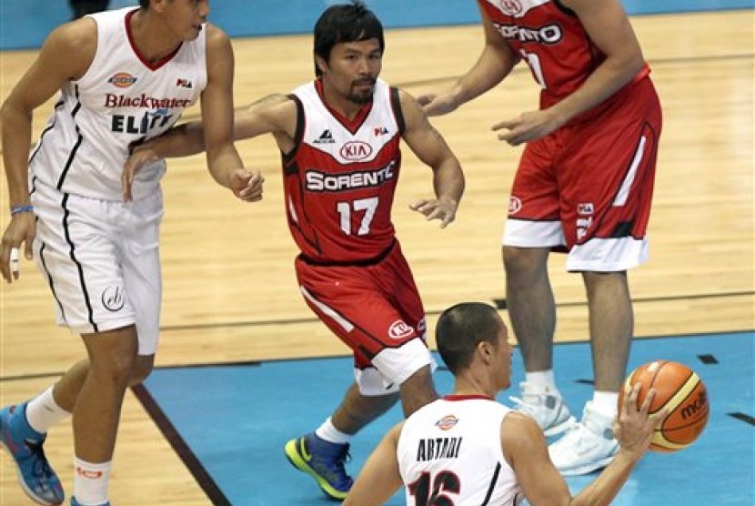 Manny Pacquiao (tengah) saat menjalani debut di kompetisi basket profesional Filipina, PBA, Ahad (19/10).