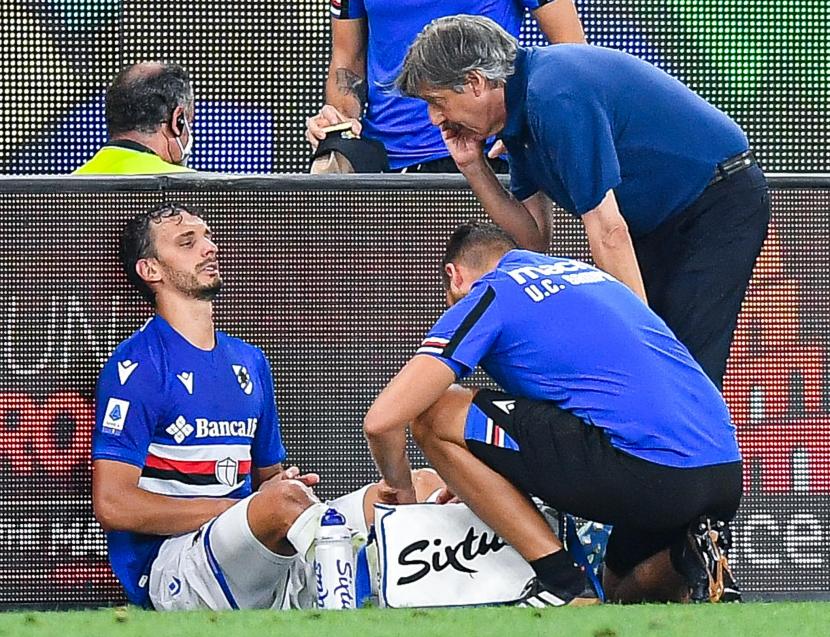Manolo Gabbiadini (kiri) mendapat perawatan akibat cedera saat memperkuat Sampdoria melawan AC Milan, Selasa (24/8).