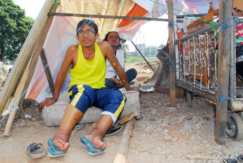 Mantan atlet senam nasional Amin Ikhsan (depan) berada di tenda pengungsian di lokasi pembongkaran lahan kawasan Kiaracondong, Bandung, Jawa Barat, Jumat (7/8). 