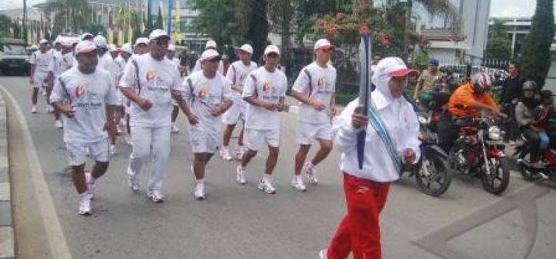 Mantan atlit panahan Kaltim, Hamdiah bersama bersama 70 pelari membawa obor SEA Games XXVI untuk diarak di sejumlah jalan protokol di Samarinda, Kalimantan Timur, Rabu (2/11).