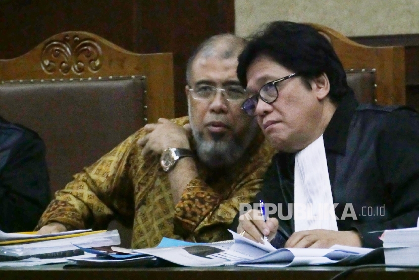 Mantan hakim Konstitusi Patrialis Akbar (kiri) nampak berdiskusi bersama tim penasehat hukumnya pada sidang lanjutan mendengarkan kesaksian para saksi di pengadilan tipikor Jakarta, Senin (10/7). 