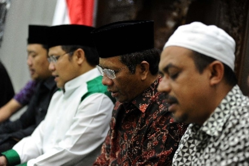 Mantan Ketua MK Mahfud MD (tengah), Ketua Umum PKB Muhaimin Iskandar membacakan surat Yasin di Jakarta, Selasa (4/3). 