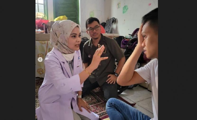 Mantan kiper Timnas Indonesia, Kurnia Meiga (kanan), menjalani pemeriksaan mata oleh dokter dari RSPP di kediamannya di Cijantung, Jakarta Timur, Ahad (21/5/2023).