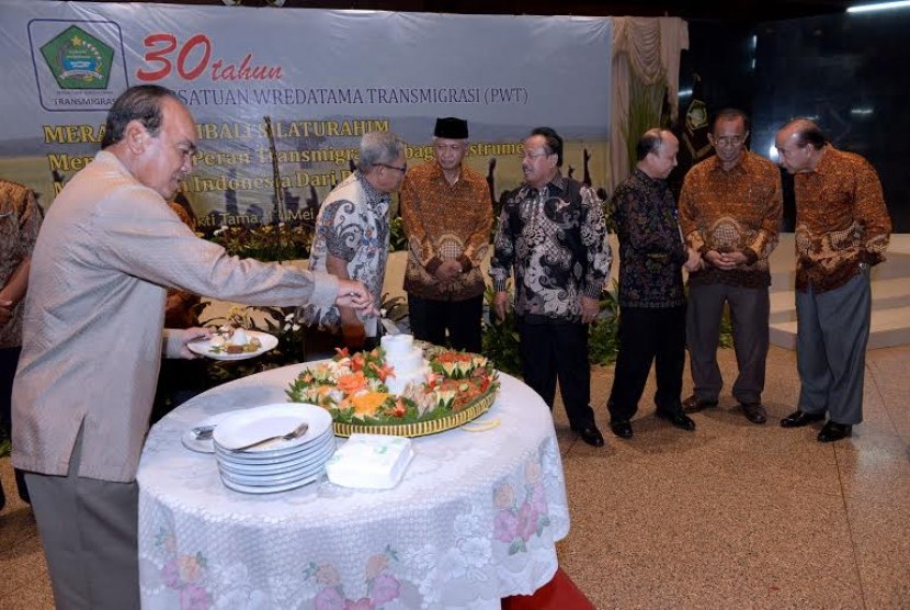 Mantan Menteri Transmigrasi dan Permukiman Perambah Hutan Siswono Yudo Husodo (kiri) memotong tumpeng pada peringatan 30 Tahun Persatuan Wredatama Transmigrasi (PWT) di Balai Makarti Mukti Tama, Jakarta, Selasa (17/5).