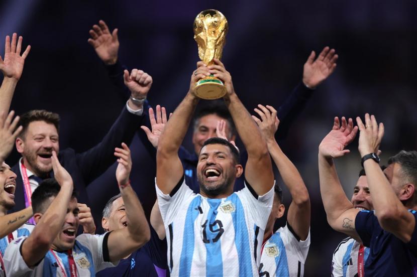  Mantan pemain sepak bola Argentina Sergio Aguero (Tengah) mengangkat trofi Piala Dunia setelah memenangkan Final Piala Dunia FIFA 2022 antara Argentina dan Prancis di stadion Lusail, Lusail, Qatar, 18 Desember 2022.