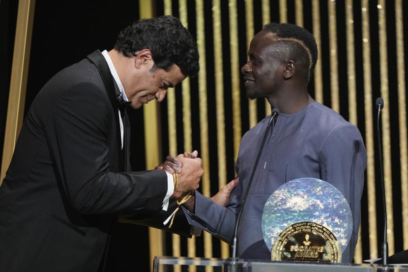  Mantan pemain Socrates (kiri)  menyerahkan The Socrates Award kepada pemenang Sadio Mane dari Bayern Munich saat upacara Ballon d