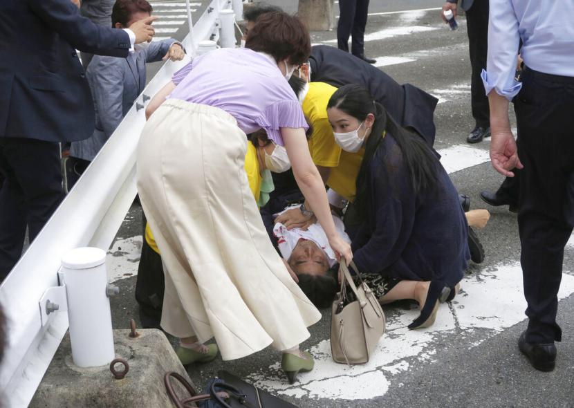 Mantan Perdana Menteri Jepang Shinzo Abe, tengah, jatuh ke tanah di Nara, Jepang barat Jumat, 8 Juli 2022. Abe mengalami gagal jantung setelah tampaknya ditembak saat berpidato pada pidato kampanye Jumat di Jepang barat, kata televisi publik NHK, Jumat.