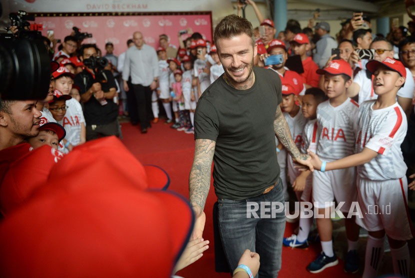 Mantan pesepak bola Manchester United dan Real Madrid David Beckham menyapa penggemarnya saat tiba di Stadion Soemantri Brojonegoro, Jakarta, Ahad (25/3). 