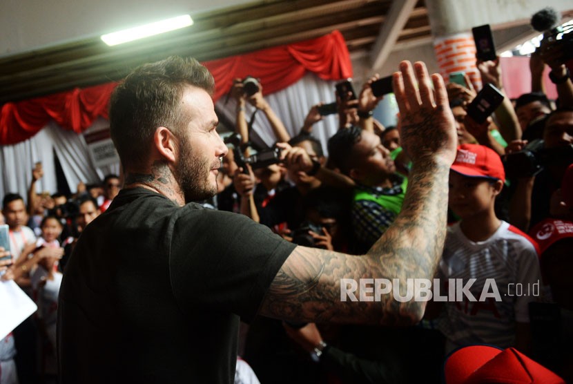 Mantan pesepak bola Manchester United dan Real Madrid David Beckham menyapa penggemarnya saat tiba di Stadion Soemantri Brojonegoro, Jakarta, Ahad (25/3). 