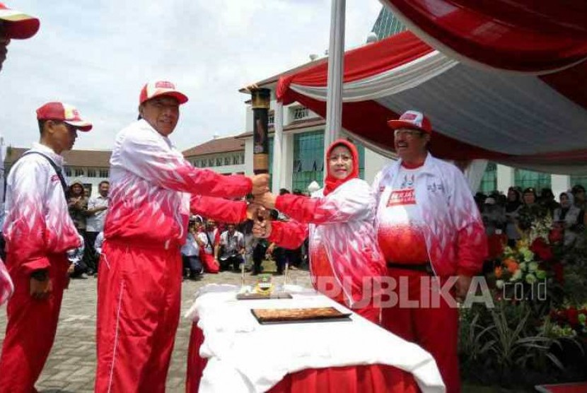 Mantan Pesepakbola Robby Darwis menerima obor Api i PON XIX 2016 dari Ketua  Koni  Kab Bandung Barat Elin Suherlan. 