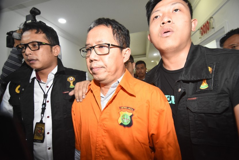 Mantan Plt Ketua Umum PSSI Joko Driyono (tengah) mengenakan rompi tahanan seusai menjalani pemeriksaan di Ditreskrimum Polda Metro Jaya, Jakarta, Selasa (26/3/2019) dinihari.