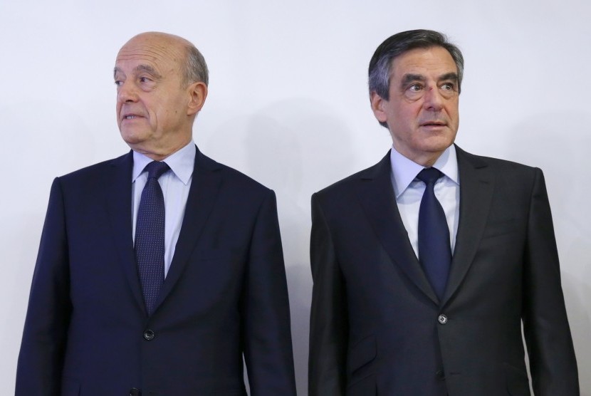 Mantan PM Prancis Francois Fillon (kanan) bersama lawannya Alain Juppe berpose usai keluarnya hasil Pilpres Prancis di putaran pertama, Senin (28/11).