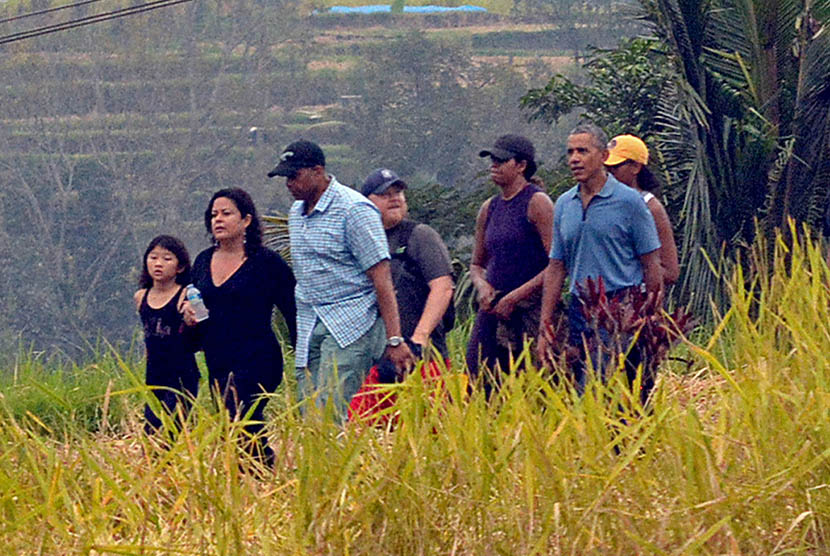 Mantan Presiden Amerika Serikat Barack Obama (keenam dari kiri) berjalan bersama keluarga saat berkunjung ke objek wisata Jatiluwih, Tabanan, Bali, Ahad (25/6). 