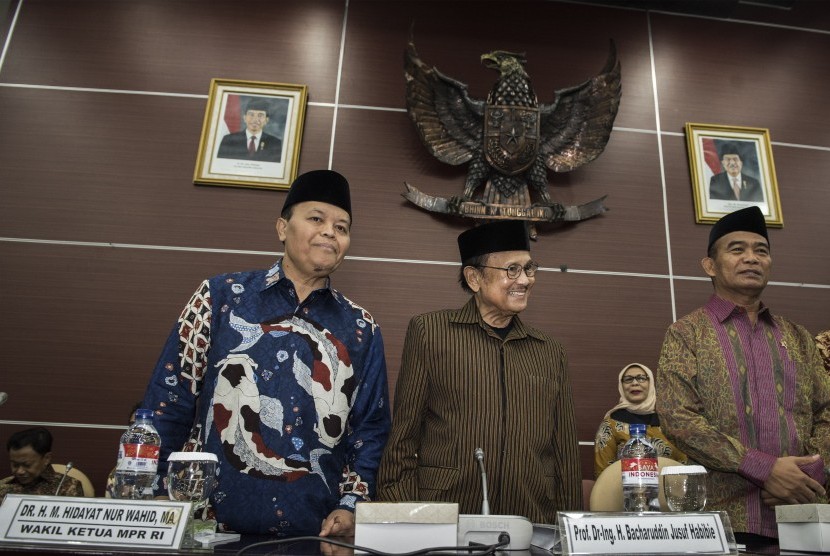 Ketua Lembaga Pengkajian MPR Rully Chairul Azwar (kanan) memberikan buku kepada Mantan Presiden B.J Habibie (tengah) disaksikan Wakil Ketua MPR Hidayat Nur Wahid (kiri) saat menghadiri rapat Pleno Lembaga Kajian MPR di ruang GBHN, Kompleks Parlemen Senayan, Jakarta, Selasa (22/8).