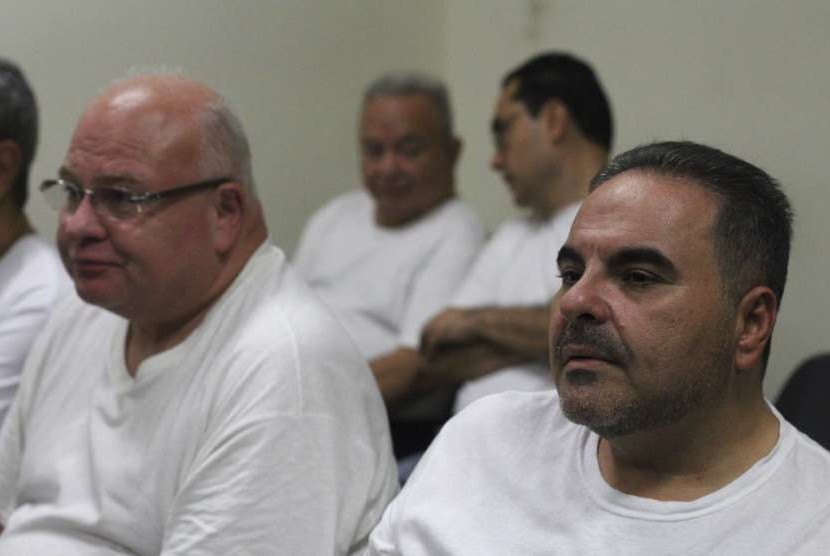 Mantan presiden El Salvador Antonio Saca (kanan) bersama pejabat pemerintahan lain yang dituduh korupsi saat audiensi dengan hakim di Isidro Menendez Judicial Complex di San Salvador, El Salvador, Selasa (7/8).
