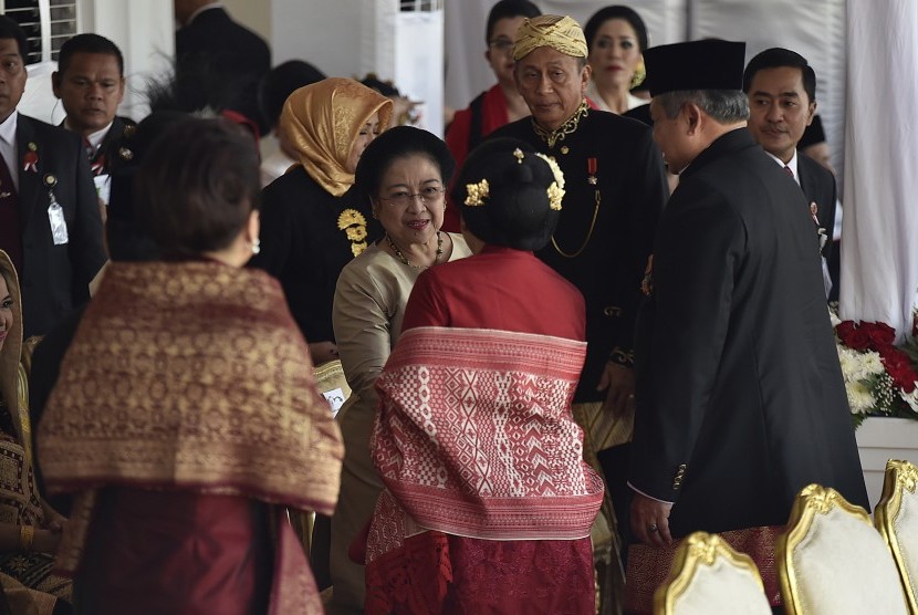 Mantan Presiden Megawati Soekarnoputri (tengah) berjabat tangan dengan mantan Presiden Susilo Bambang Yudhoyono (kanan) beserta istri Ani Yudhoyono (kedua kanan) saat menghadiri upacara peringatan detik-detik proklamasi kemerdekaan RI di Istana Merdeka, Jakarta, Kamis (17/8).