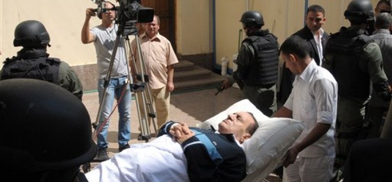 Mantan Presiden Mesir, Hosni Mubarak, tergolek di atas tempat tidurnya ketika digiring ke ruang sidang di Akademi Kepolisian Kairo, Mesir, Kamis (8/9).