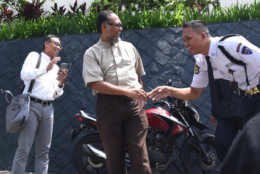 Mantan Wakil Ketua KPK Bambang Widjojanto (tengah) bersalaman dengan petugas keamanan KPK seusai mengunjungi Gedung KPK, Jakarta, Jumat (4/3).