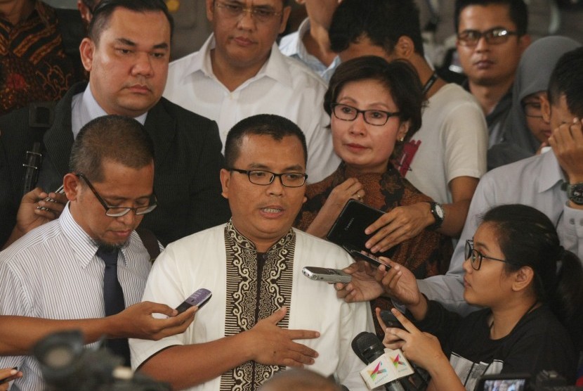 Mantan Wakil Menteri Hukum dan Hak Asasi Manusia Denny Indrayana (tengah) bersama tim penasehat hukumnya menjawab pertanyaan wartawan sebelum memasuki gedung Bareskrim Polri, Jakarta, Kamis (12/3). 