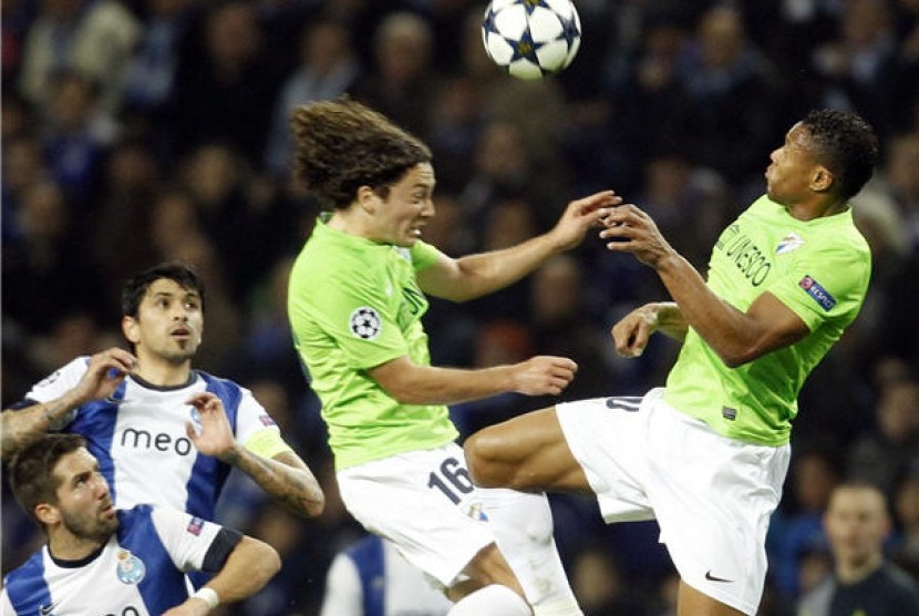 Manuel Iturra (tengah), gelandang Malaga, duel udara dengan pemain Porto (kiri) dalam laga Liga Champions di Stadion Dragao, Porto, pada 19 Februari. 