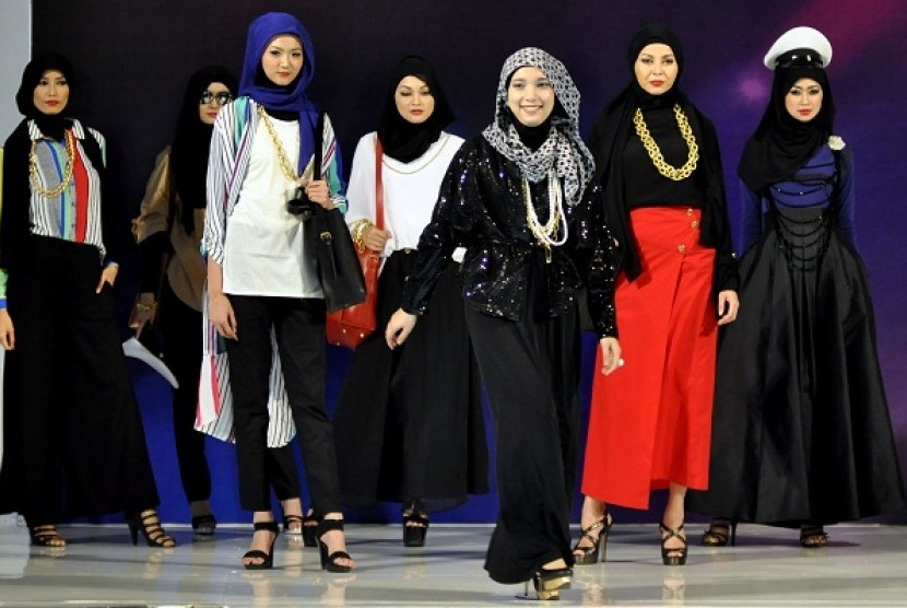Indonesian Muslim designer poses with models in runaway. (illustration)