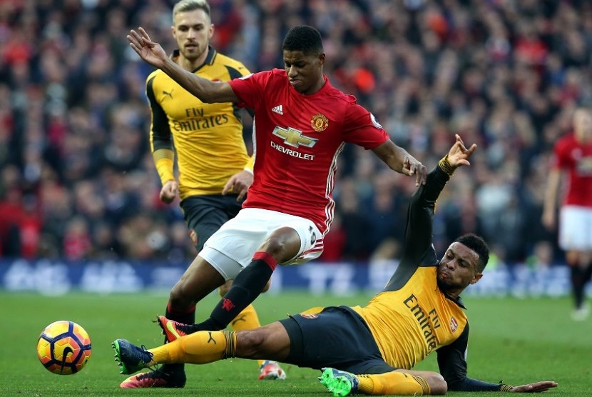 Marcus Rashford berebut bola dengan penggawa Arsenal, Francis Coquelin dalam bigmatch Liga Inggris antara Manchester United melawan Arsenal, Senin (19/11). Kedua tim bermain imbang 1-1.