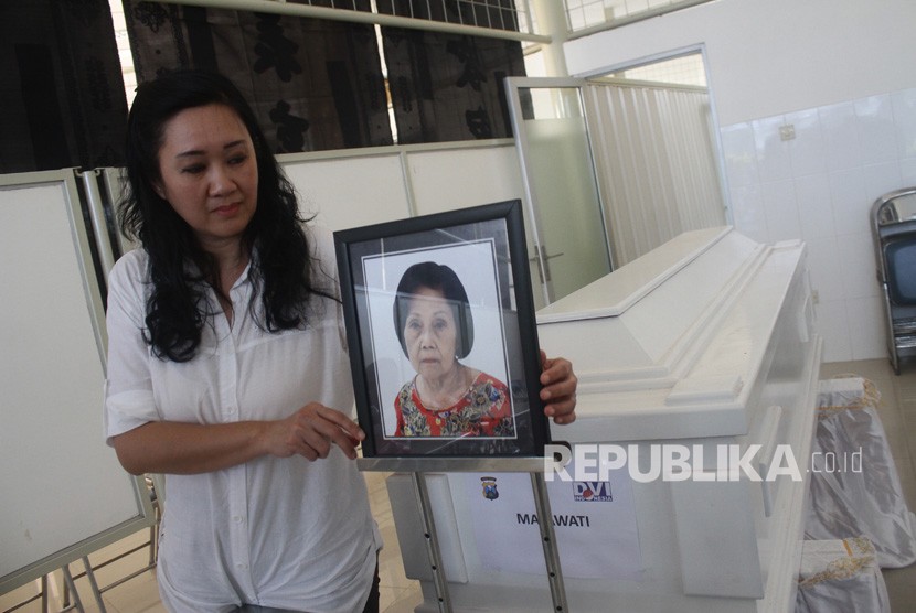 Maria Hamdani, memasang foto bibinya, Mayawati yang menjadi korban bom gereja Surabaya di Rumah Persemayaman Gotong Royong, Malang, Jawa Timur, Senin (14/5). 