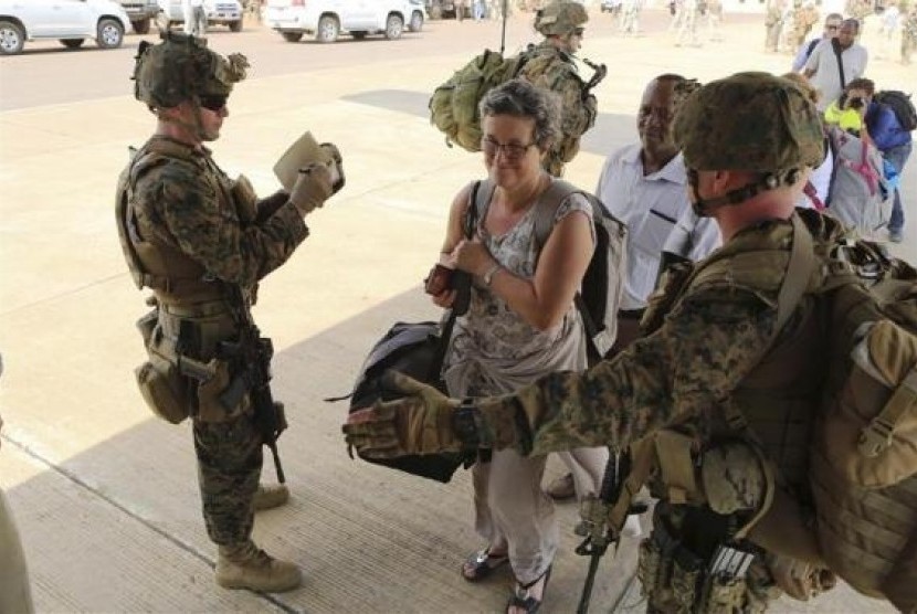 Marines and sailors with Special-Purpose Marine Air-Ground Task Force Crisis Response help US  citizens into a Marine Corps KC-130J Hercules airplane during an evacuation of personnel from the US Embassy, in Juba, South Sudan, January 3, 2014, 