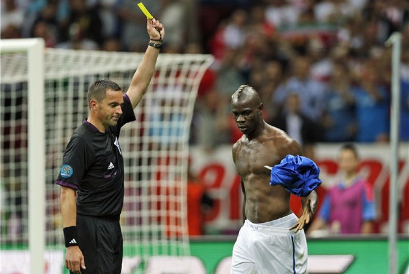  Mario Balotelli (kanan), striker timnas Italia, diganjar kartu kuning karena melakukan selebrasi lepas baju usai menjebol jala Jerman di semifinal Piala Eropa 2012. 