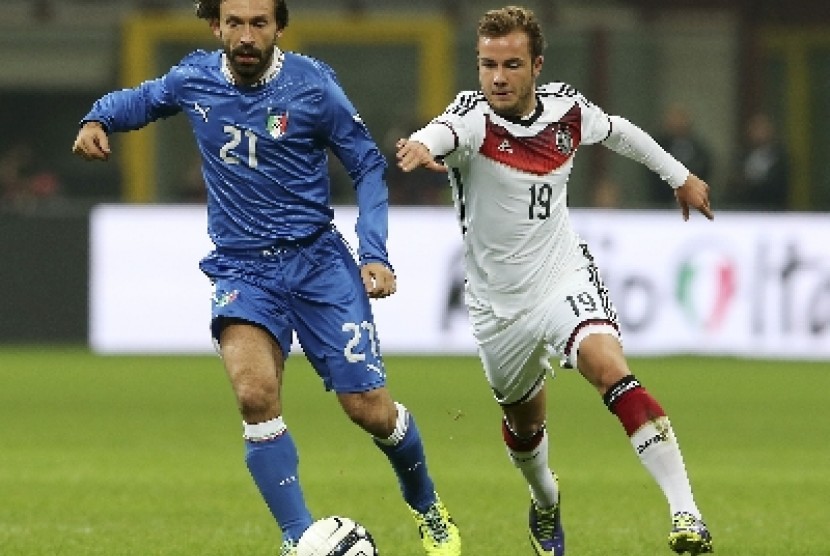 Mario Goetze (kiri) berebut bola dengan Andrea Pirlo.