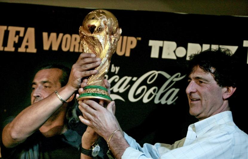 Mario Kempes (kanan) mengangkat trofi Piala Dunia dengan legenda sepak Argentina lainnya, Sergio Batista. 