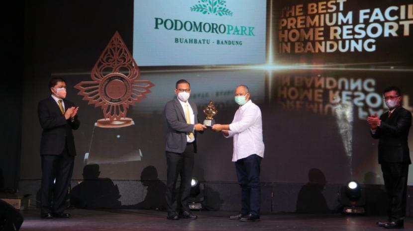 Marketing GM Tedi Guswana, perwakilan PT Pesona Mitra Kembar Mas (Podomoro Park Bandung) memegang piala penghargaan best premium facilities home resort dari Indonesia Property&Bank Award