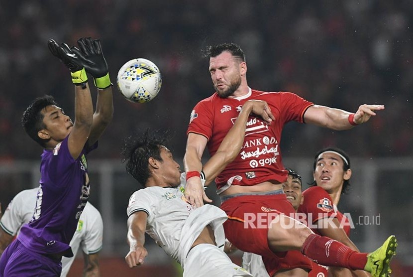 Striker Persija Jakarta Marko Simic (kedua kanan) berusaha menyundul bola melewati kawalan penjaga gawang Persebaya Surabaya yang kini membela PSM Makassar Miswar Saputra (kiri).