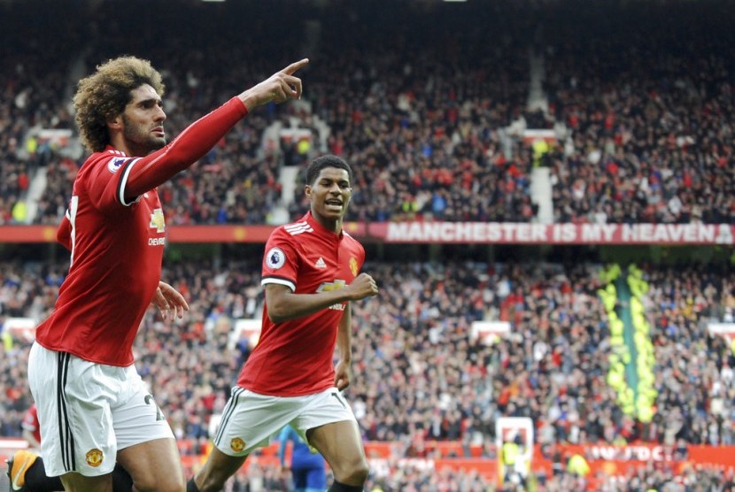 Marouane Fellaini (kiri) merayakan keberhasilannya menjebol gawang Arsenal.