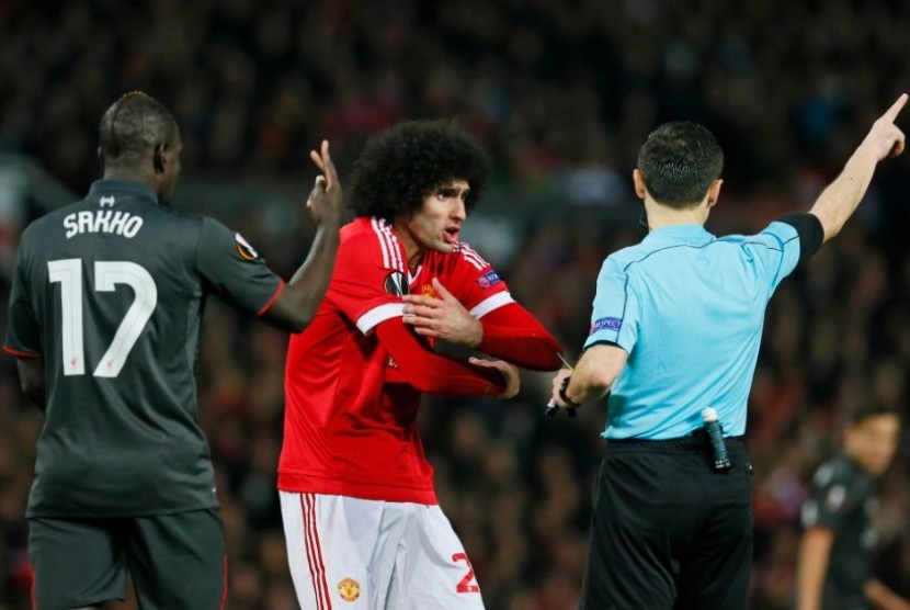 Marouane Fellaini (tengah) saat mendapatkan peringatan dari wasit.