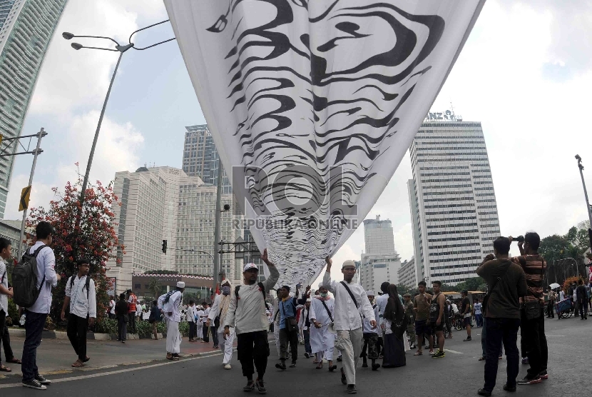  Masa dari sejumlah ormas Islam menggelar parade tauhid Indonesia saat melintas di kawasan Bundaran HI, Jakarta, Ahad (16/8).