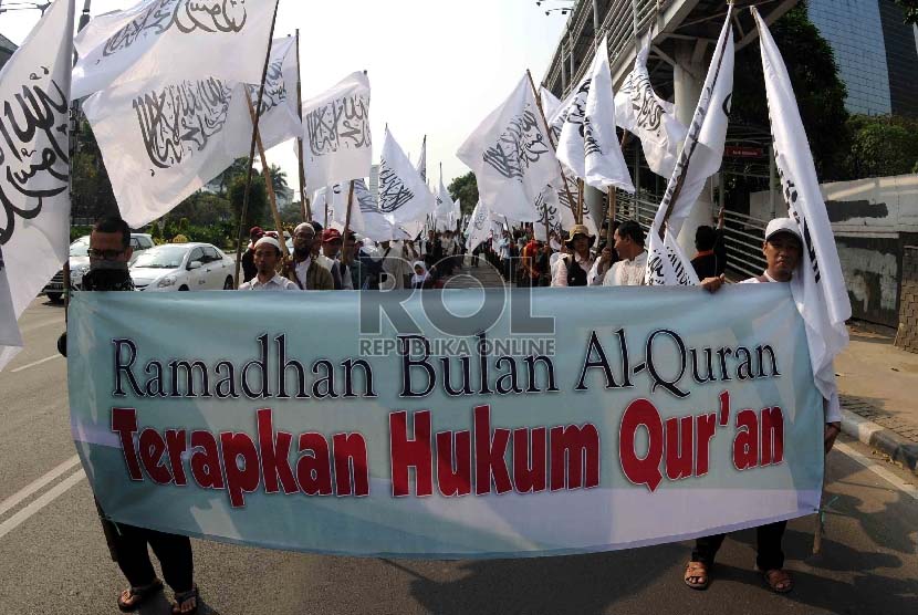 Masa Hizbut Tahrir Indonesai (HTI) membawa spanduk Ramadhan saat menggelar pawai dan Tahrib Ramadhan di Jalan Thamrin, Jakarta, Sabtu (13/6). 