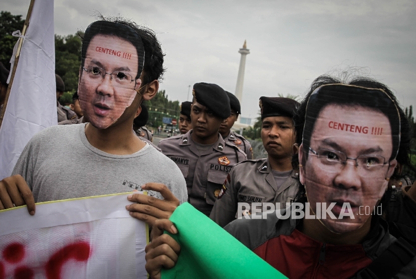 Masa yang tergabung dalam Aliansi Pro Demokrasi memakai topeng Gubernur Provinsi DKI Jakarta Basuki Tjahaja Purnama saat melakukan aksi di Silang Monas, Jakarta, Jumat (30/9).