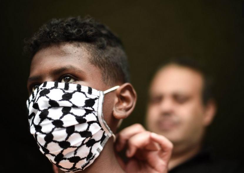 Masker motif keffiyeh buatan seniman Palestina.