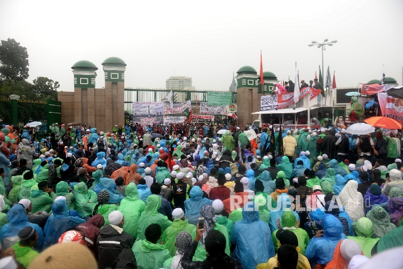  Massa Aksi 212 memadati pintu gerbang DPR RI dalam guyuran hujan, Jakarta, Selasa (21/2). 