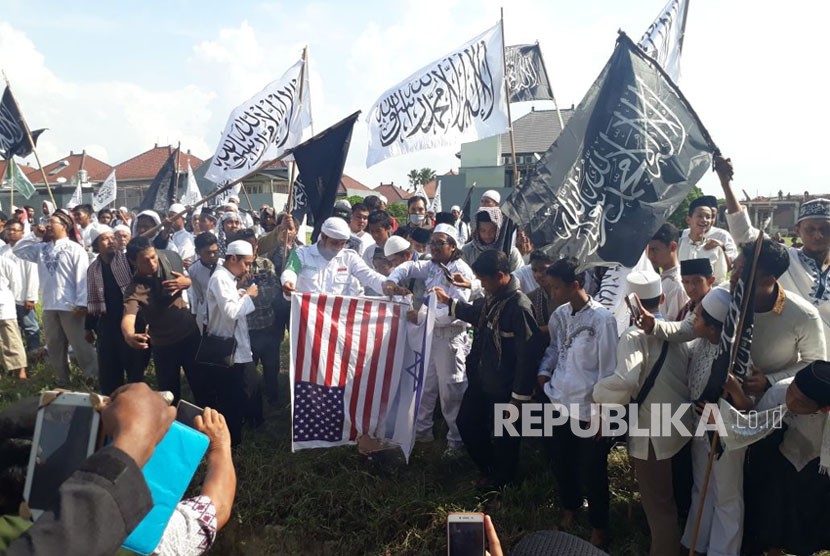 Massa aksi bela Palestina membakar replika bendera Amerika Serikat dan bendera Israel di sekitaran kantor Konsulat Jenderal Amerika Serikat Surabaya Jalan Citra Niaga, Sambikerep, Surabaya, Jumat (15/12). 