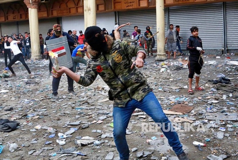 Massa anti pemerintah melempar bom molotov ke arah petugas keamanan dalam unjukrasa di Baghdad, Irak, Kamis (28/11).