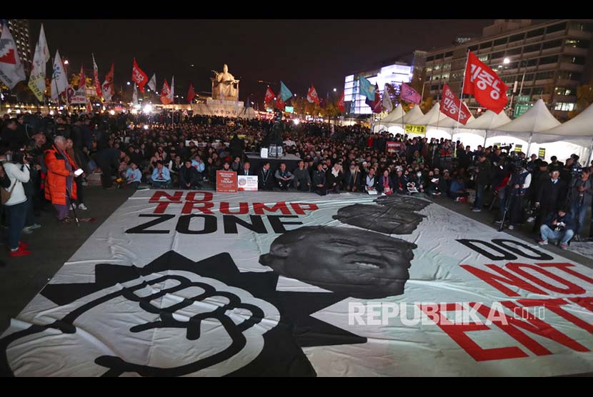 Massa anti Trump membawa baliho berukuran raksasa bergambarkan presiden Amerika tersebut di pusat Kota Seoul, Korea Selatan, Selasa (7/11)