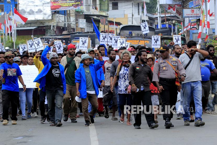 Massa berjalan kaki menuju Kantor Gubernur Papua saat melakukan aksi di Jayapura, Senin (19/8). Aksi tersebut untuk menyikapi peristiwa yang dialami mahasiswa asal Papua di Surabaya, Malang dan Semarang.