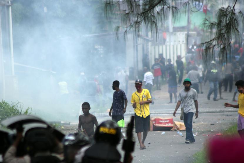 Massa berjalan melintasi asap yang mengepul saat unjuk rasa di Kota Sorong, Papua Barat, Jumat (27/11/2020). (Ilustrasi)
