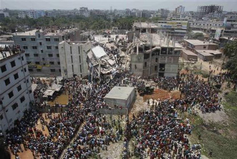 Massa berkumpul di lokasi runtuhnya gedung di luar Dhaka, Bangladesh, Kamis (25/4). Insiden ini kemudian memicu protes para buruh.