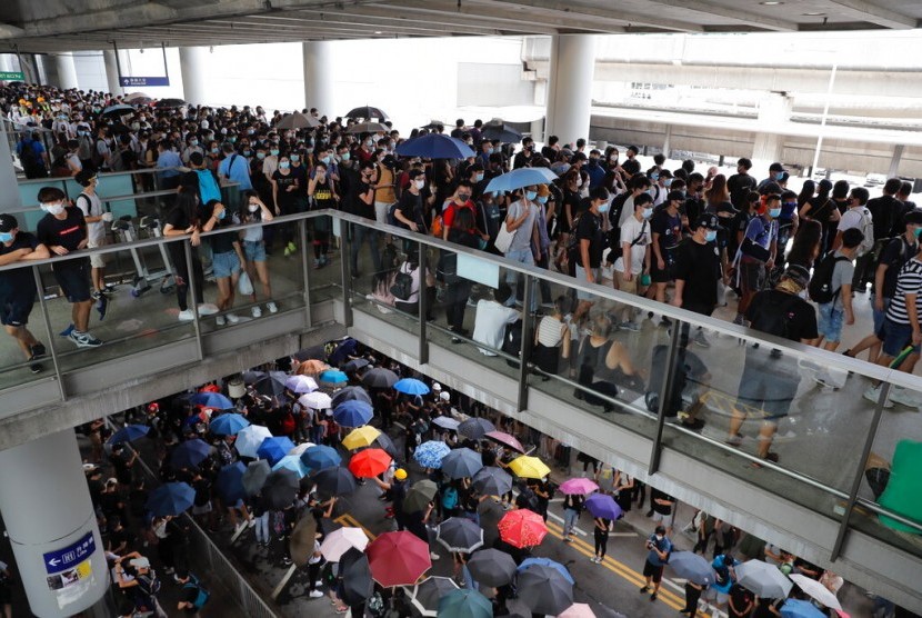 Massa berkumpul di luar Bandara Hong Kong, Ahad (1/9). Operator kereta ekspres di Bandara Hong Kong menunda operasionalnya akibat aksi massa.