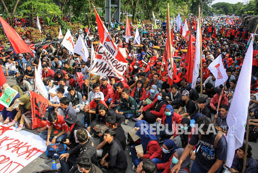 Massa buruh dan mahasiswa yang tergabung dalam aliansi Gerakan Tolak Omnibus Law (GETOL) berunjuk rasa di Jalan Frontage Ahmad Yani, Surabaya, Jawa Timur, Rabu (11/3/2020). 